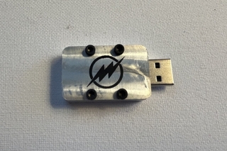 A metal flash drive case with an engraving of a lightning bolt logo representing the superhero logo for The Flash