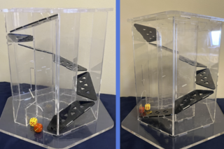 Two views of a transparent plastic dice tower with dice falling through a hexaogonal spiral staircase in the middle